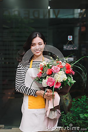 Female sales assistant working as florist and holding bouquet Stock Photo