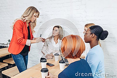 Female Sales Consultant telling about new goods to young business women Stock Photo