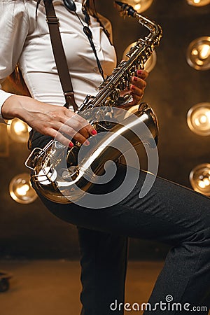 Female saxophonist plays the saxophone on stage Stock Photo