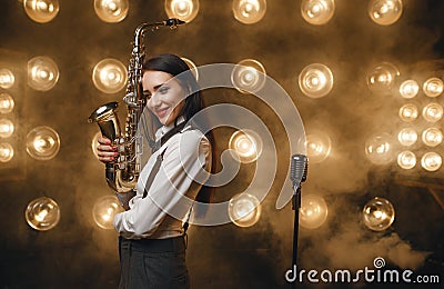 Female saxophonist poses with saxophone on stage Editorial Stock Photo