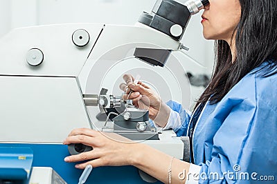 Female scientist placing a sample on a transmission electron microscopy grid Stock Photo