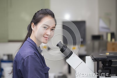 Female scientist preparing a microscope in laboratory Stock Photo