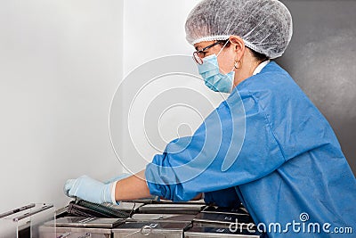 Female scientist staining microscope slides for cytology studies in the laboratory Stock Photo