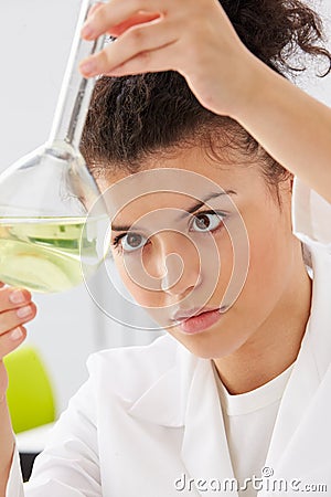 Female Scientist Studying Liquid In Flask Stock Photo