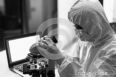 Female scientist working in research lab examining microorganisms through microscope Stock Photo