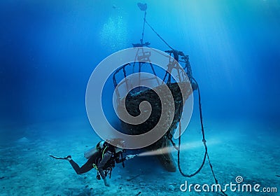 A female scuba diver explores a sunken shipwreck Stock Photo