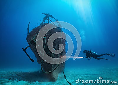 Female scuba diver explores a sunken shipwreck at the Maldives islands Stock Photo