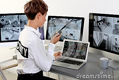 Female security guard with portable transmitter monitoring home cameras Stock Photo