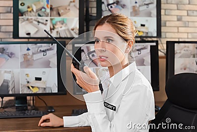 Female security guard with portable transmitter at workplace. Stock Photo