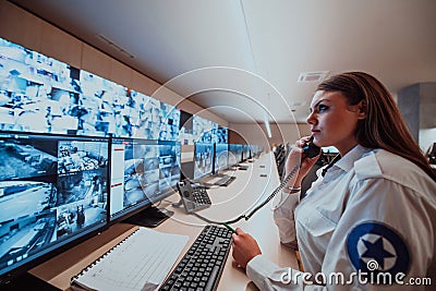 Female security operator working in a data system control room offices Technical Operator Working at workstation with Stock Photo