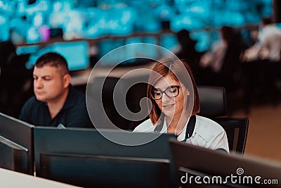 Female security operator working in a data system control room offices Technical Operator Working at workstation with Stock Photo