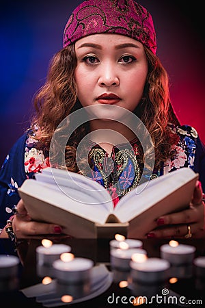 Female seer teller doing psychic reading book Stock Photo