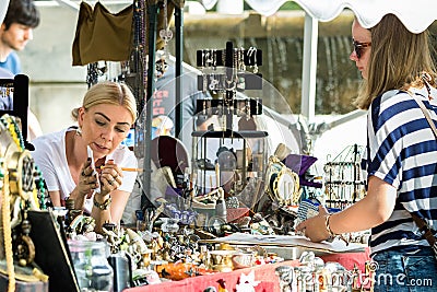 A female seller discussing the price with a customer at an antique street market in Split, Croatia Editorial Stock Photo
