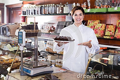 Female seller offering festive chocolate cake Stock Photo