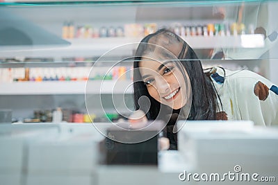 female seller smiling while taking the vape mod Stock Photo