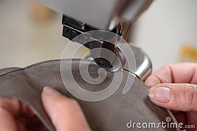 Female shoemaker hands stitching leather craft shoes on sewing machine. Artisan handmade manufacturing leather shoes Stock Photo