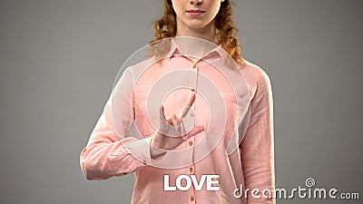 Female showing love in asl, text on background, nonverbal communication for deaf Stock Photo