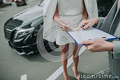 Female signing contract for purchasing car outside Stock Photo