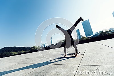 Skateboarder doing a handstand on skateboard in city Stock Photo