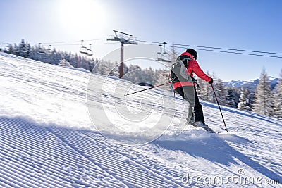 Female skiier dressed in red jacket enjoys slopes. Editorial Stock Photo