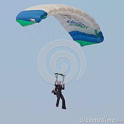 Female sky diver with brightly coloured open parachute gliding i Editorial Stock Photo