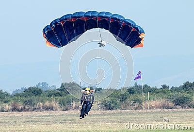 Female skydiver making safe landing on grass with open brightly Editorial Stock Photo