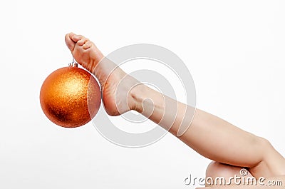 Female slender legs with Christmas balls on toes Stock Photo