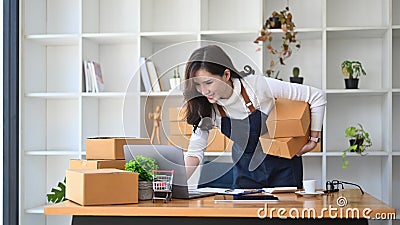 Female small business owner preparing deliveries for clients at her home office. Stock Photo