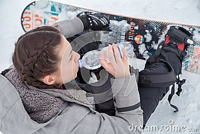 Female snowboarder is drinking for quenching the thirst Stock Photo