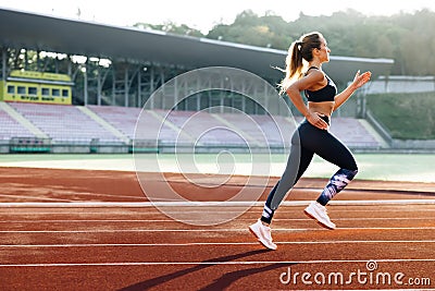 Female sprinter race on outdoor track arena. Female marathon runner on professional sports arena. Fitness woman racing Stock Photo