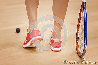 Female squash player hiting a ball in a squash court Stock Photo