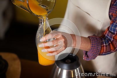 Female staff pouring juice in a bottle Stock Photo