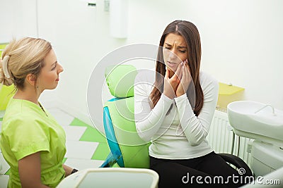 Female stomatologist in protective gloves examining patient`s teeth. Dentist caries treatment at dental clinic office Stock Photo