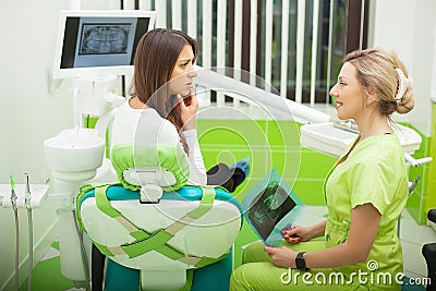 Female stomatologist in protective gloves examining patient`s teeth. Dentist caries treatment at dental clinic office Stock Photo