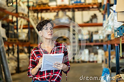 Female storekeeper checks presence of goods in the building materials warehouse Stock Photo