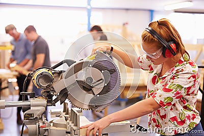 Female Student In Carpentry Class Using Circular Saw Stock Photo