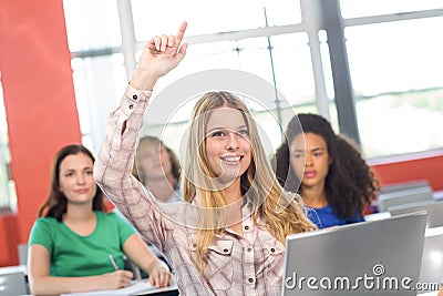 Female student raising hand in classroom Stock Photo