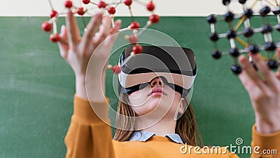 Female student wearing virtual reality glasses, holding molecular structure model. Science class, Education, VR, New Technologies. Stock Photo