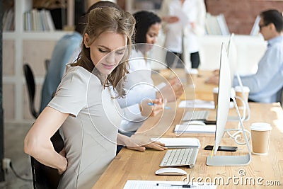 Female suffering from low back pain at work Stock Photo