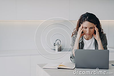 Female suffers migraine headache during laptop work, solves working problem at home. Stress, burnout Stock Photo