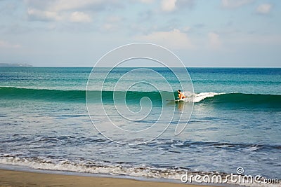 Female surfer riding a beginner wave in Bali Editorial Stock Photo