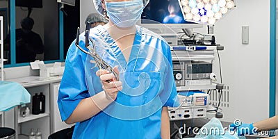 A female surgeon in the operating room holds an anus dilator. Stock Photo