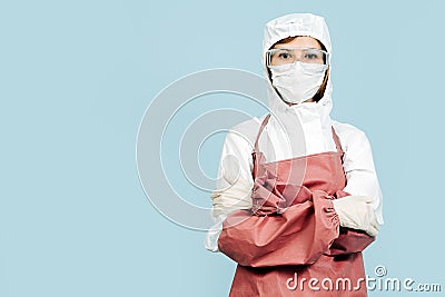 Surgeon standing with her hands crossed with red leather apron and sleeves Stock Photo