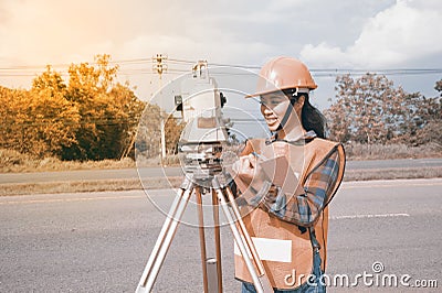 Female Surveyor or Engineer making measure on the highway. Stock Photo