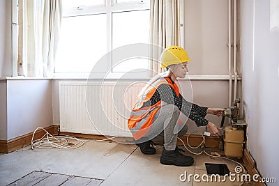 Female Surveyor In Hard Hat And High Visibility Jacket Checking Gas Supply Stock Photo