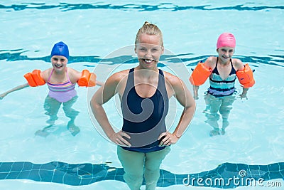 Female swimming trainer with girls in swimming pool Stock Photo