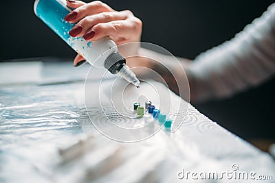 Female tattooist hand with bottle of color ink Stock Photo