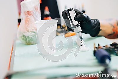 Female tattooist preparing the dyes she`s going to work with. Stock Photo