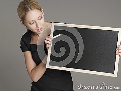 Female Teacher With Blackboard And Chalk Stock Photo