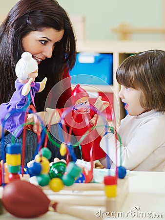 Female teacher and little girl playing Stock Photo